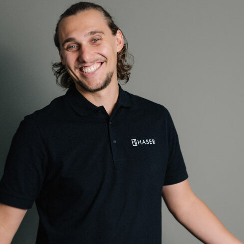 Glücklicher Mitarbeiter im schwarzen Haser-Poloshirt