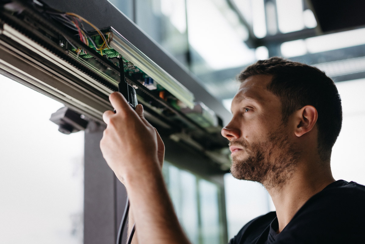 Wartung und Service-Techniker wartet automatisches Türsystem und überprüft interne Komponenten.