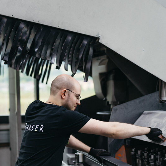 Konzentrierter Arbeiter, der eine CNC-Maschine bedient und eine Karriere in der Fertigung vorführt.