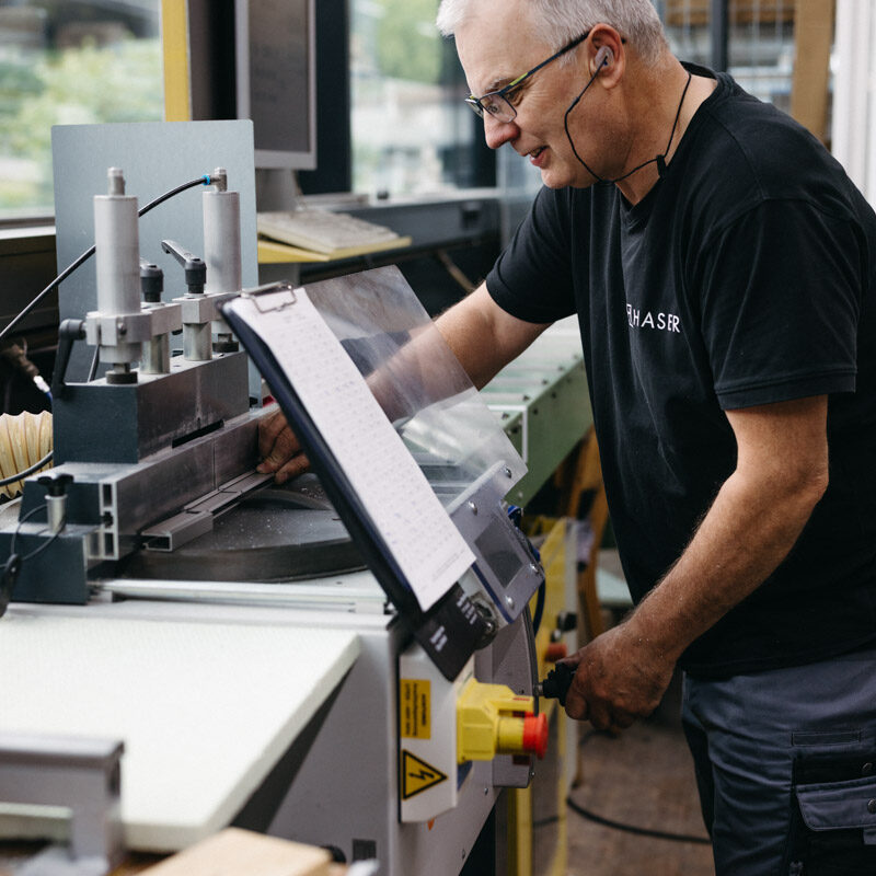 Mann, der eine Holzbearbeitungsmaschine bedient und sich auf seine Karriere konzentriert.