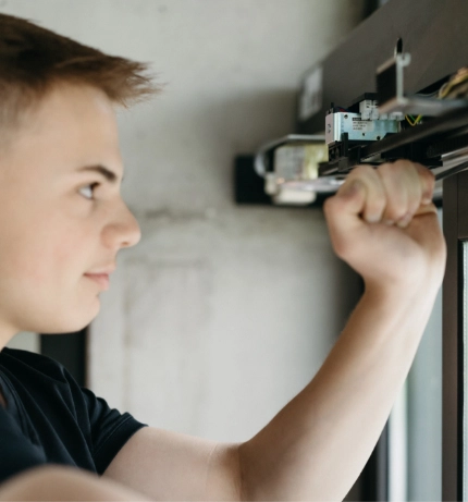 Junger Mann installiert während eines Praktikums Fenstermechanismen.