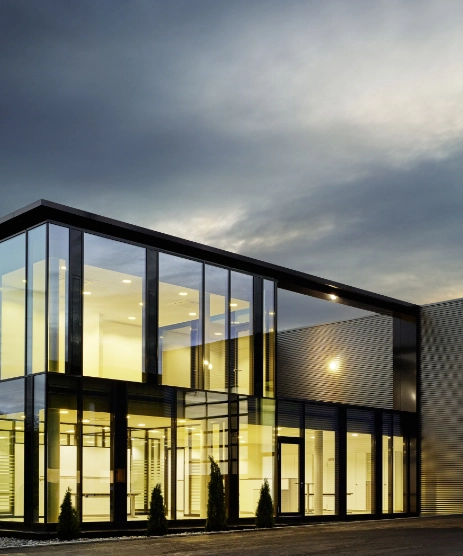 Modernes Bürogebäude mit Glasfront in der Abenddämmerung