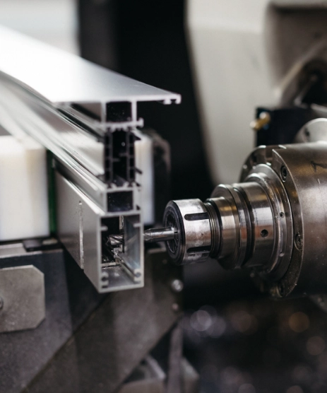 Nahaufnahme einer CNC-Maschine, die ein Aluminiumprofil schneidet.