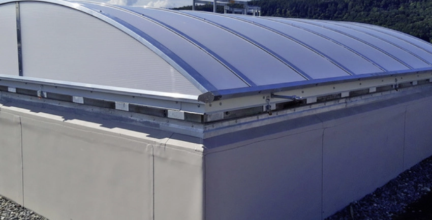 Gebogenes Dachfenster aus Polycarbonat, installiert auf einem Flachdach.