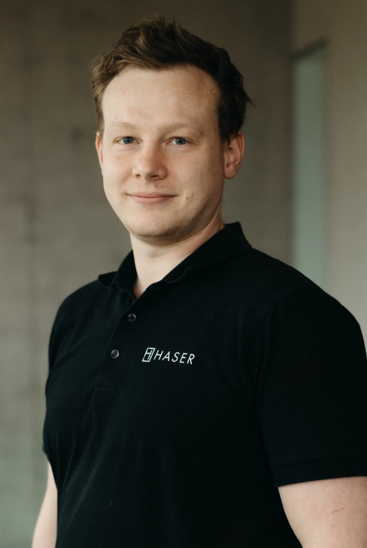 http://Porträt%20eines%20Haser-Mitarbeiters,%20der%20ein%20schwarzes%20Poloshirt%20mit%20dem%20Haser-Logo%20trägt.