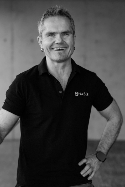 http://Lächelnder%20Mann%20in%20einem%20schwarzen%20Haser-Poloshirt